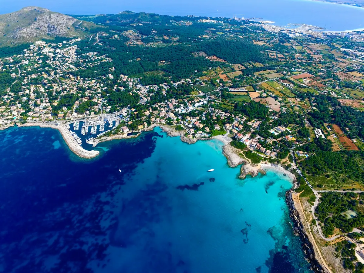 Vista de una bahía con puerto y montañas en la costa mediterránea